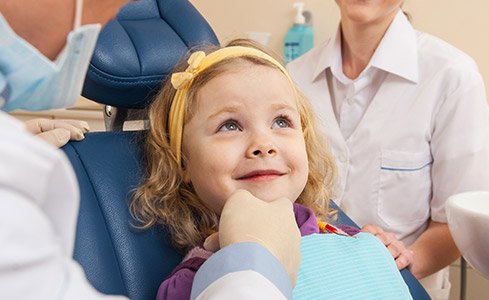 Smiling little girl in dental chair for pediatric dentistry