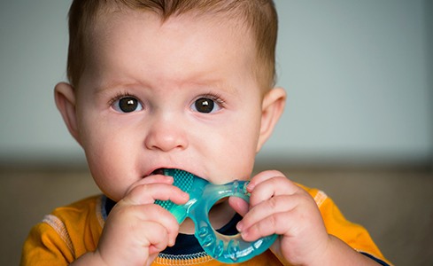 Infant with teething ring at one year old dental visit