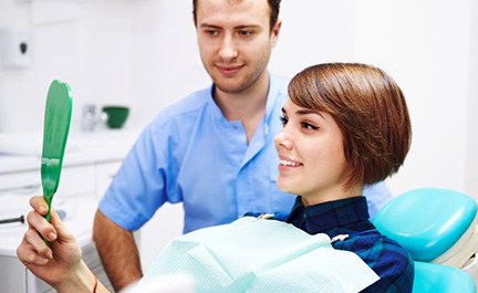 Cosmetic dentistry patient looking at her smile in mirror
