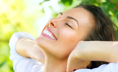 Smiling woman with dental bonding outdoors