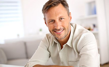 Man sitting down at table and smiling