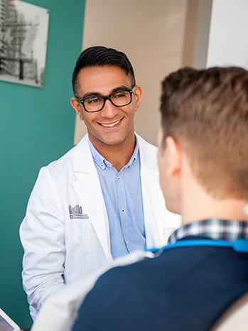 Long Island City dentist Doctor Ishwinder Saran smiling at dental patient