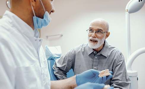 senior man asking his dentist questions about dental implants