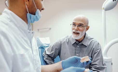 Senior man asking his dentist questions about dental implants