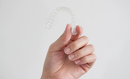 Patient holding up clear aligner