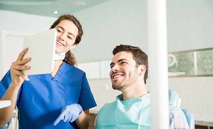 Dentist showing patient image on tablet