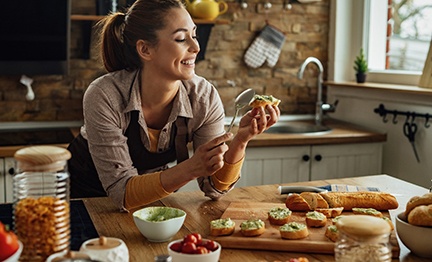 Woman smiling while making appetizer at home