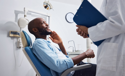 a man describing his oral pain to a dentist