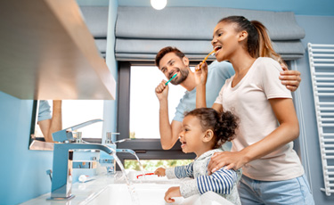 a family brushing their teeth together