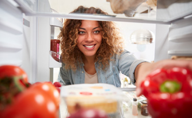 woman reaching into a refrigerator