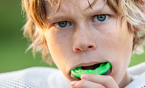 Teen boy placing green sportsguard