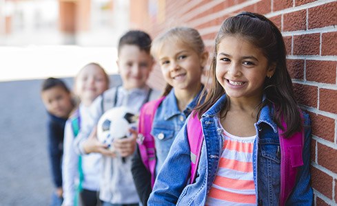 Smiling row of kids outdoors after fluoride treatments