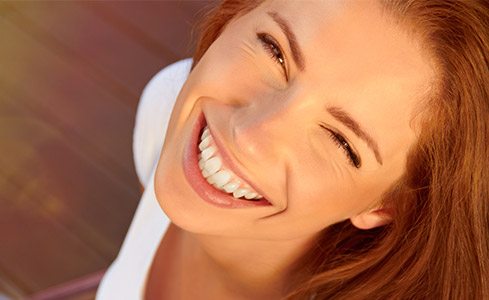 Young woman with flawless smile after tooth colored fillings