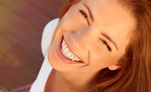 Young woman with flawless smile after tooth colored fillings
