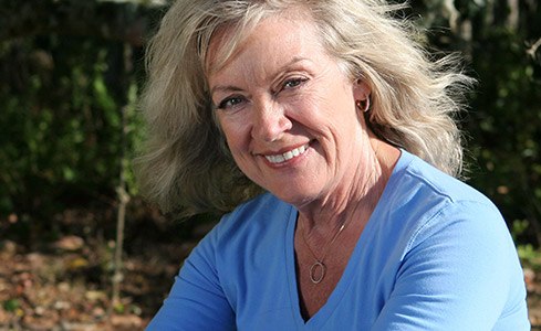 Older woman with dentures smiling outdoors