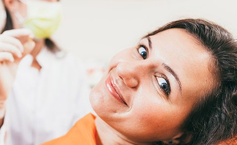 Woman smiling in dental chair after TMJ therapy