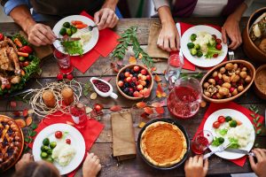 Above view of thanksgiving dinner and family eating at table