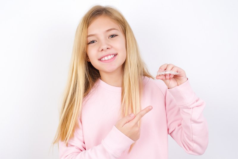 girl holding Invisalign tray in Long Island City