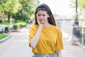 woman with toothache outside