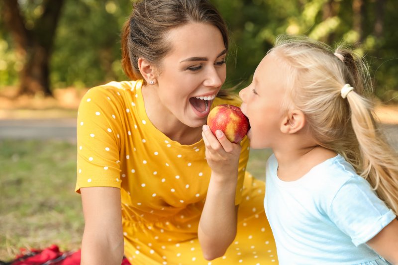 mother and daughter sharing an apple