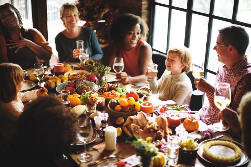 family smiling while having Thanksgiving meal 