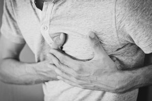 Man with chest pain grabbing his heart