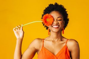 a woman with a fresh smile holding a spring flower