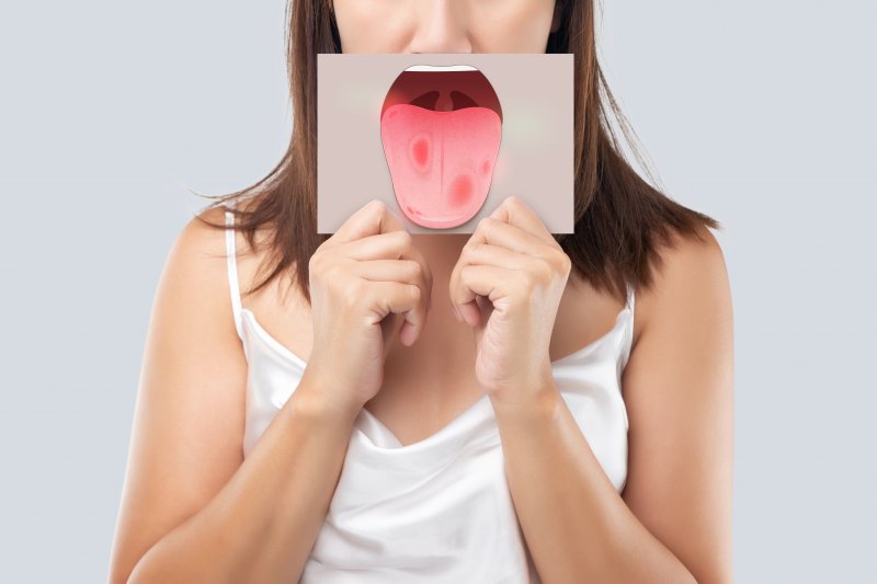 woman holding a drawing of a cancerous mouth