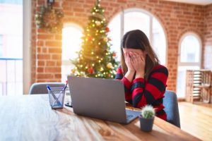 Stressed woman sitting by laptop