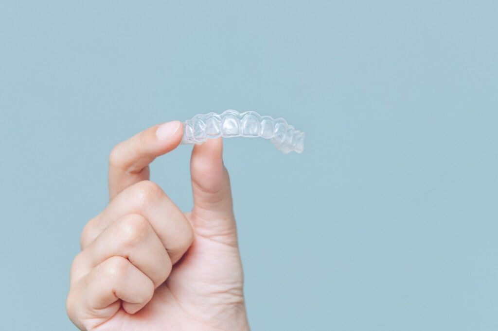 person holding Invisalign tray