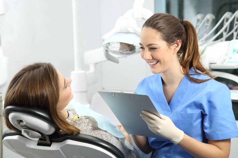 person at dental checkup speaking to dentist