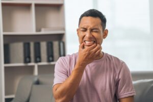 a man holding his jaw in pain
