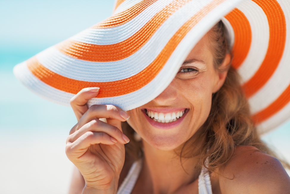 woman smiling with floppy summer hat