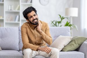 A man cringing because of a toothache